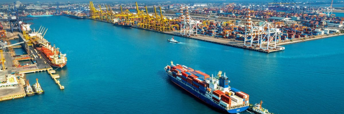 Aerial view of cargo ship and cargo container in harbor.